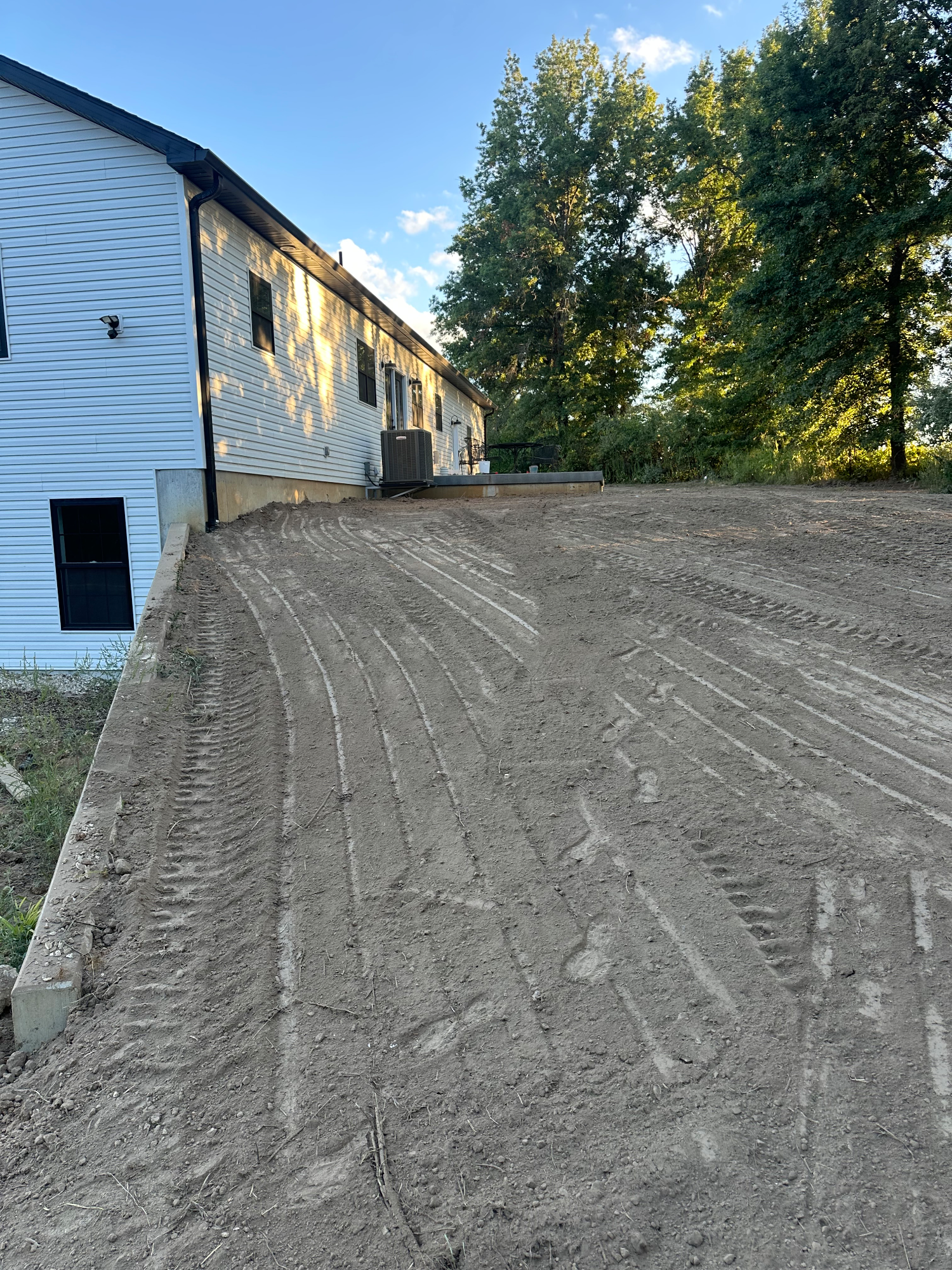 Freshly graded yard with smooth topsoil laid and even slope across the lot